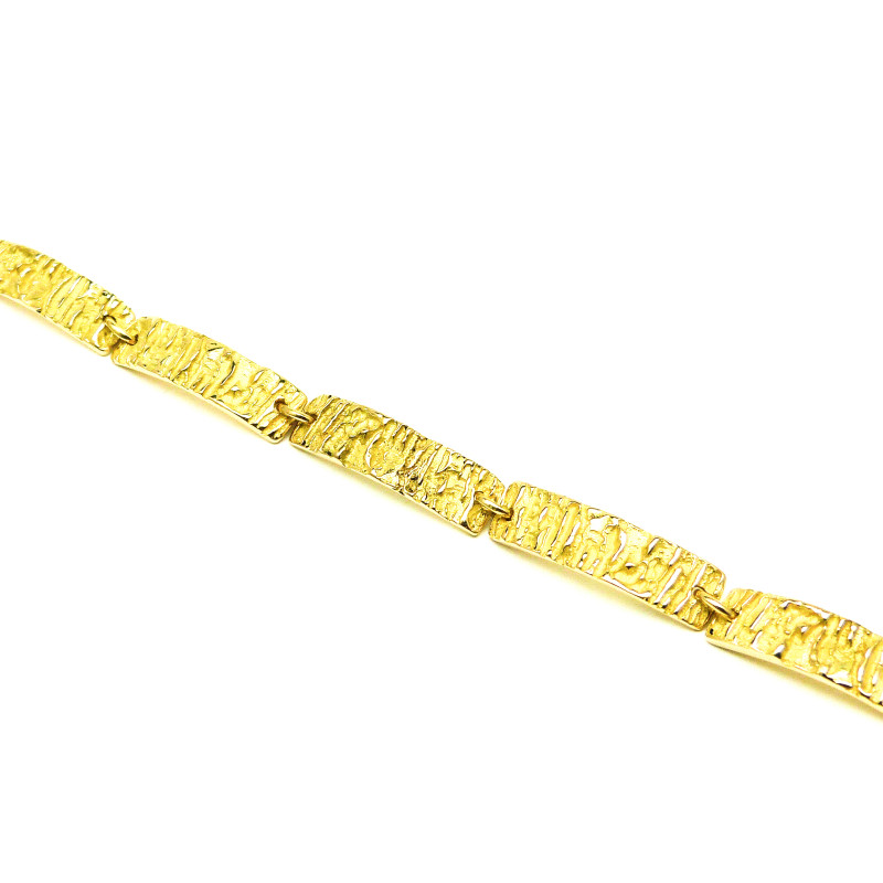 Tijdloze Geelgouden armband met een strakke rand maar speelse structuur die iets weg heeft van zonnestraaltjes.
