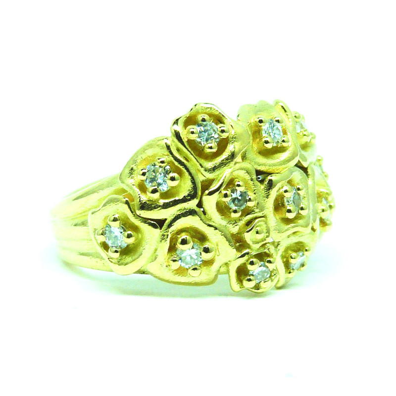 De ring is een waar boeketje bloemen, met hun meeldraden houden ze een diamantje vast. De stengels vormen de onderkant van de ring.