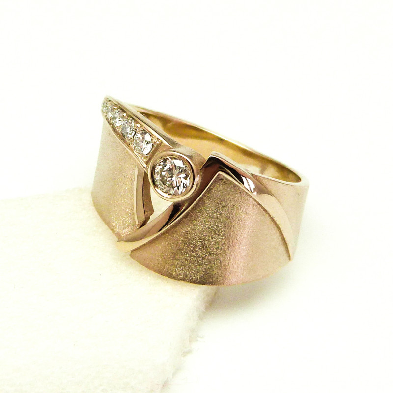 Soliede asymmetrische ring met aan de ene kant een filet Diamant van klein onderaan naar groot bovenaan, de andere kant heeft een gepolijste rand. De Filet Diamanten verbindt de 2 delen van de ring.