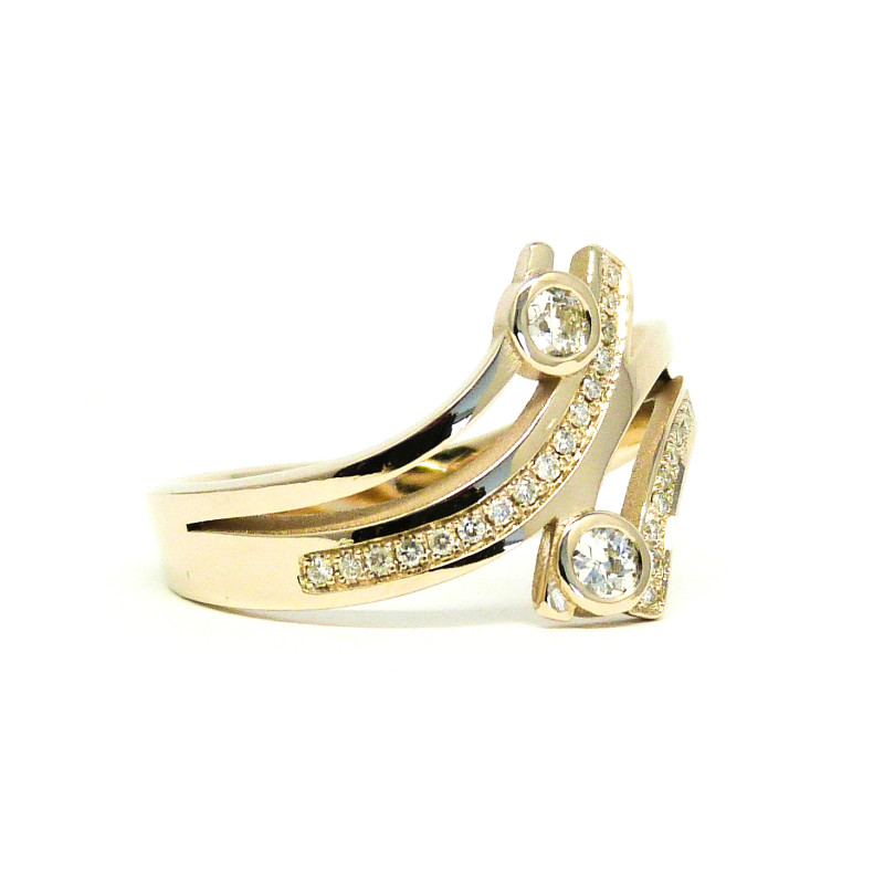 Champagne Gouden Ring met 2 banden die naar voor draaien en 2 naar achteren. 2 van de 4 banden zijn asymmetrisch gezet met hele fijne diamantjes. 2 grotere diamanten staan in kastzetting en houden de banden samen.