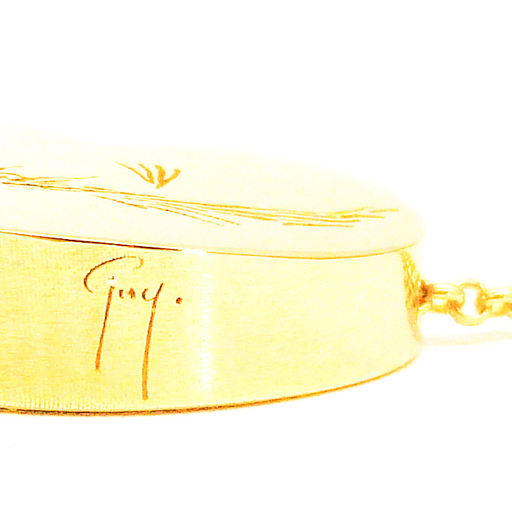RouwHanger in Geel Goud met Kunstwerkje van de Overledene. Het is eigenlijk een hartje maar zonder onderste puntje, Op de zijkant staat zijn naam in zijn handschrift.